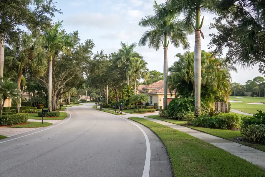 Tree-lined residential street with golf course views in Atlantis, Florida