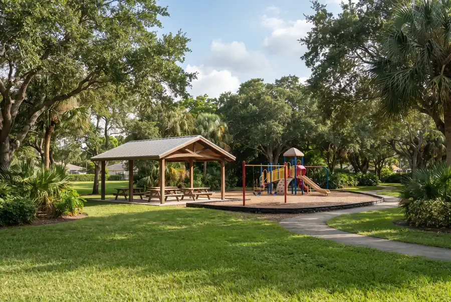 Parque de barrio con árboles de sombra y un pabellón en Greenacres, Florida